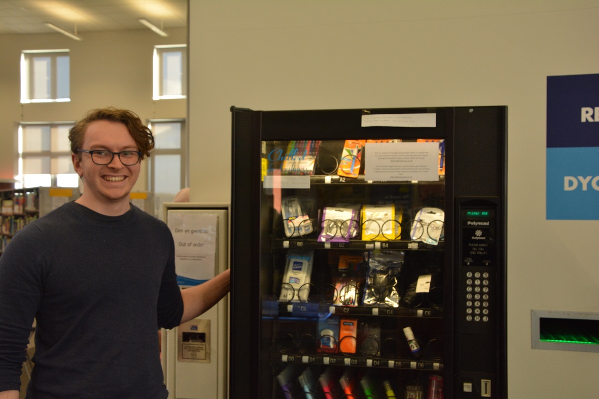 Business Studies student with vending machine 