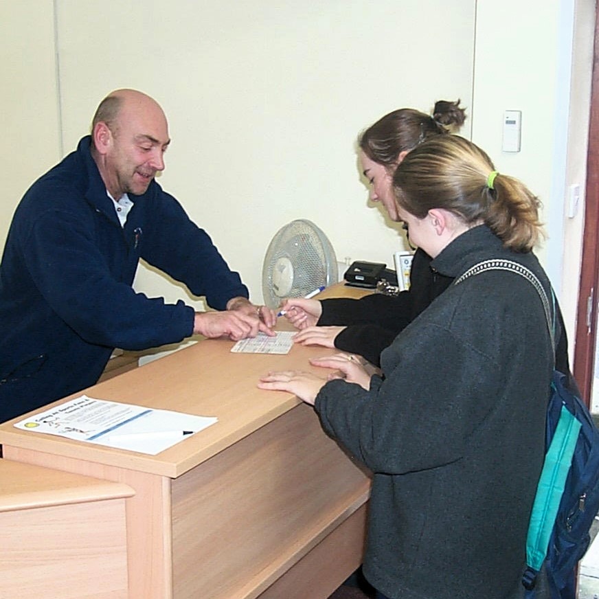 Photograph of staff member assisting residents in the Reception