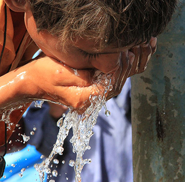 boy drinking water from well