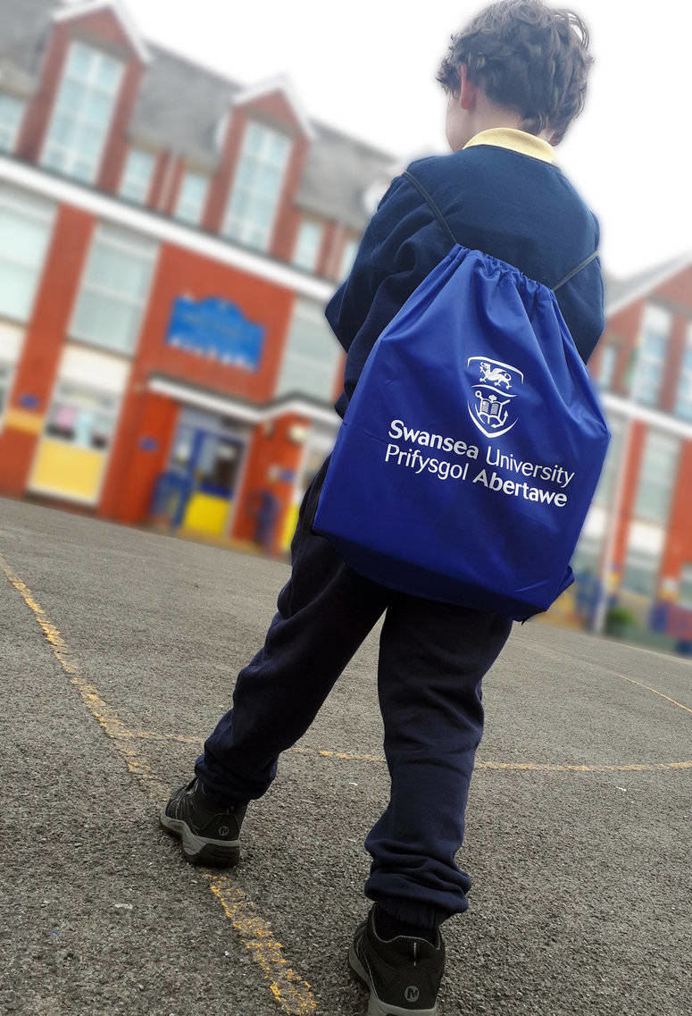 Child with back pack outside a school